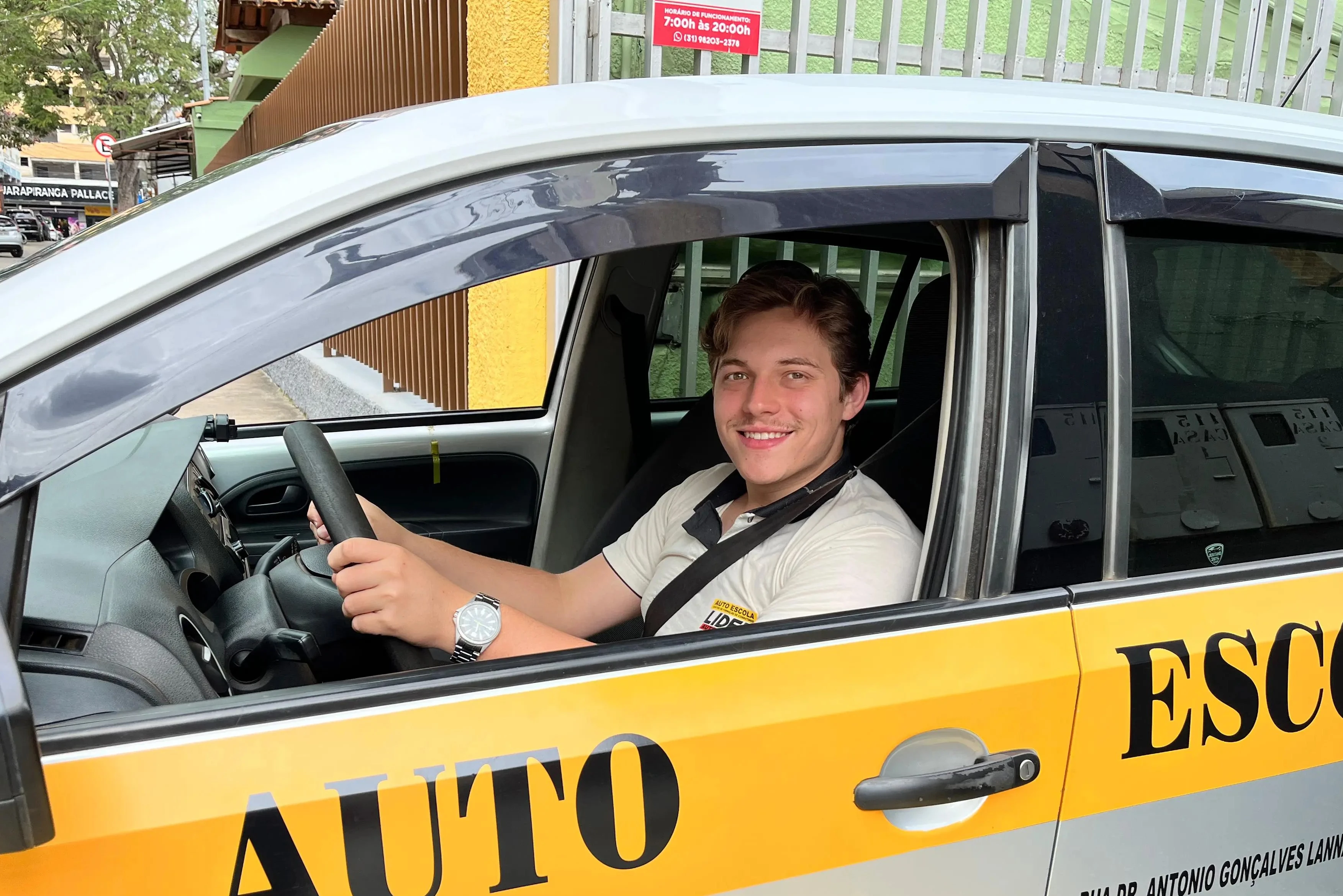 Instrutor sorrindo com as mãos no volante
